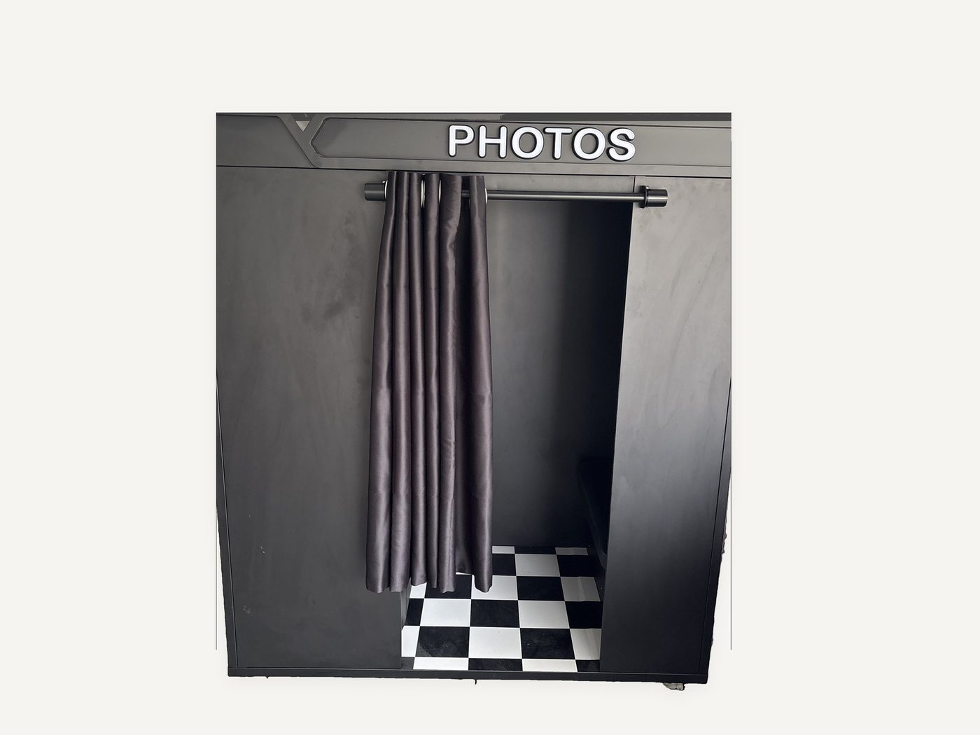 Wide front view of the black photo booth with a PHOTOS sign