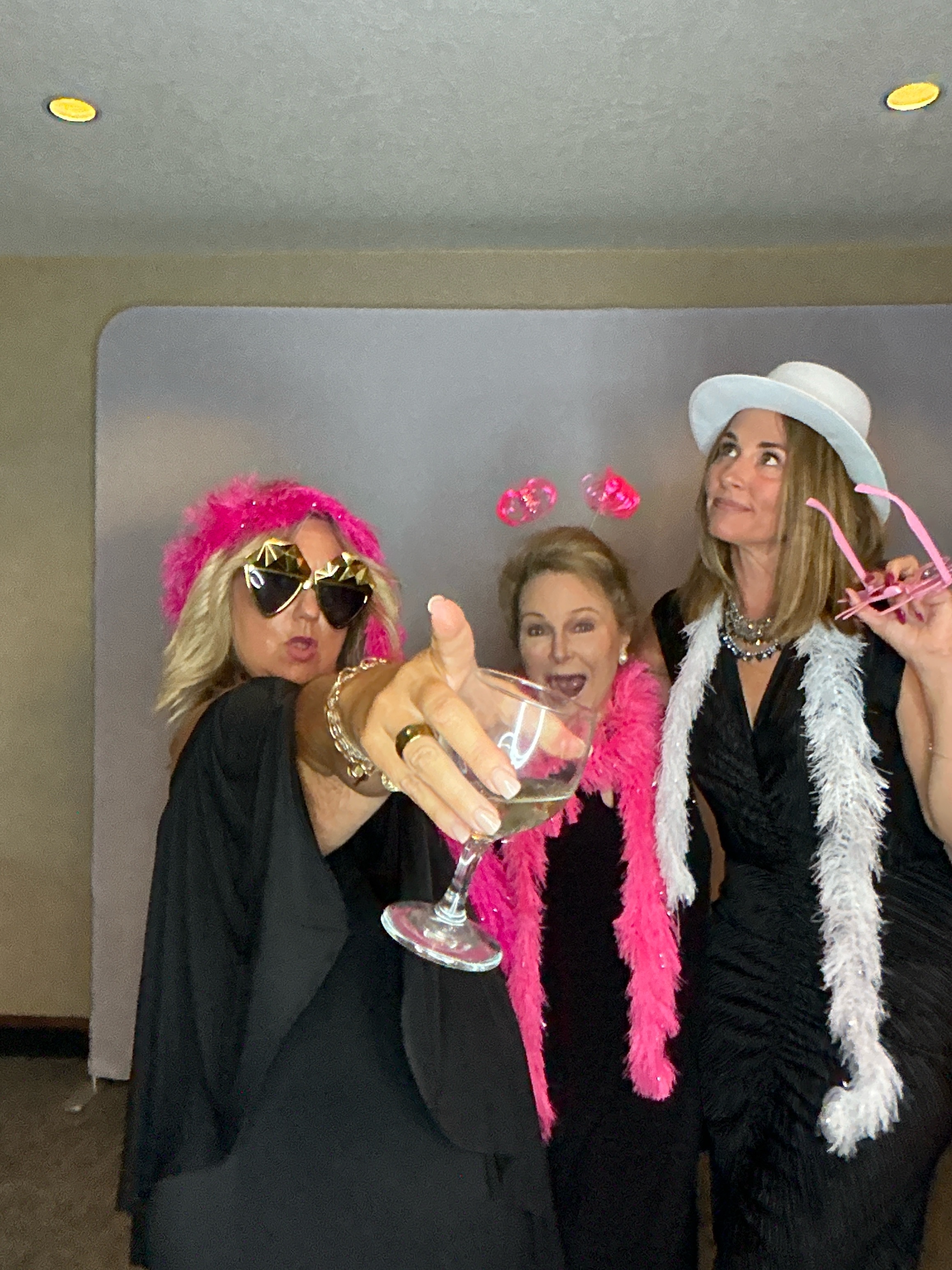 Friends celebrating with props in the Picture Perfect Events photo booth